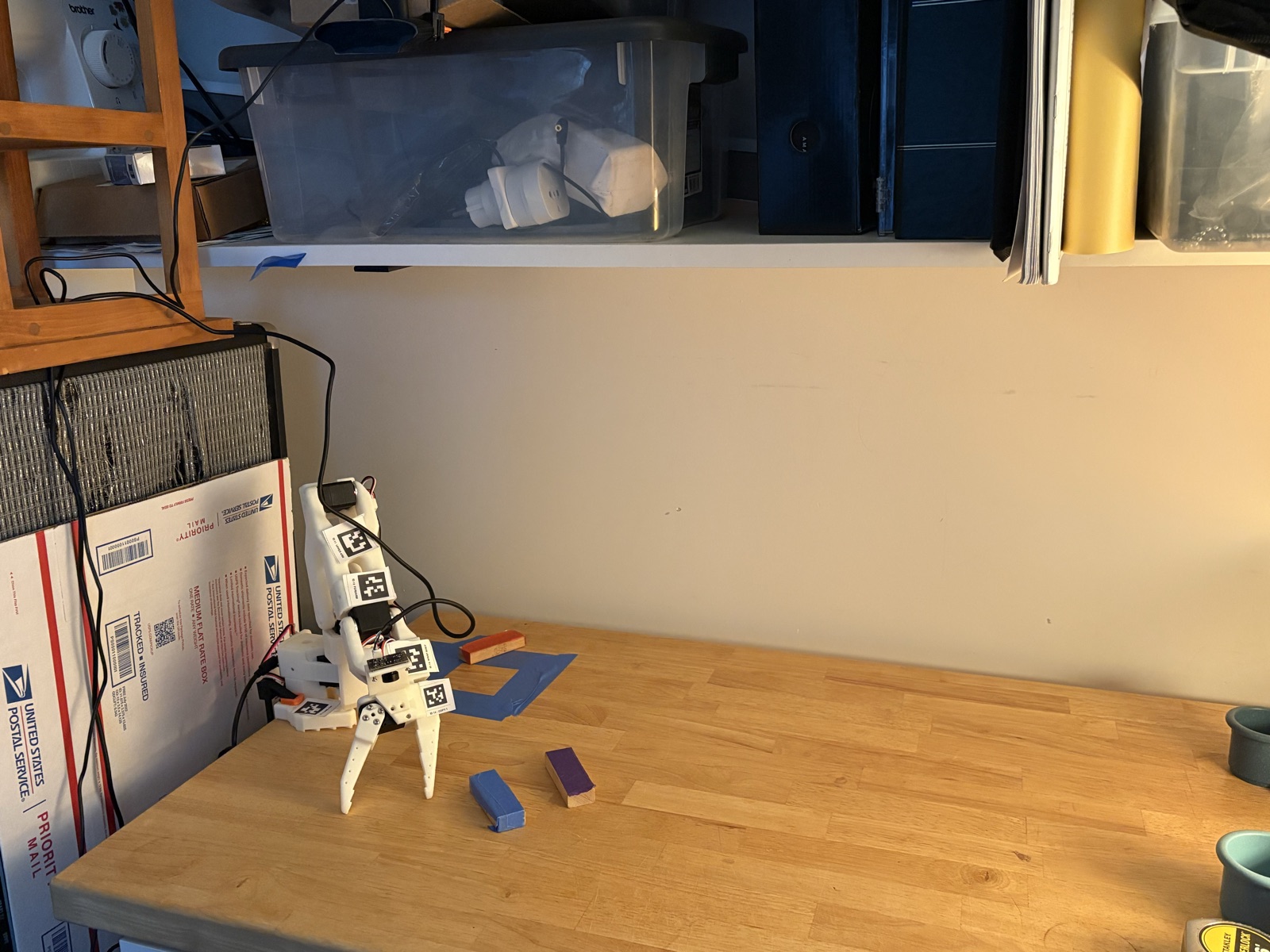 figure 1: My very primitive workspace and robot, webcam at the top of the frame pointing down.