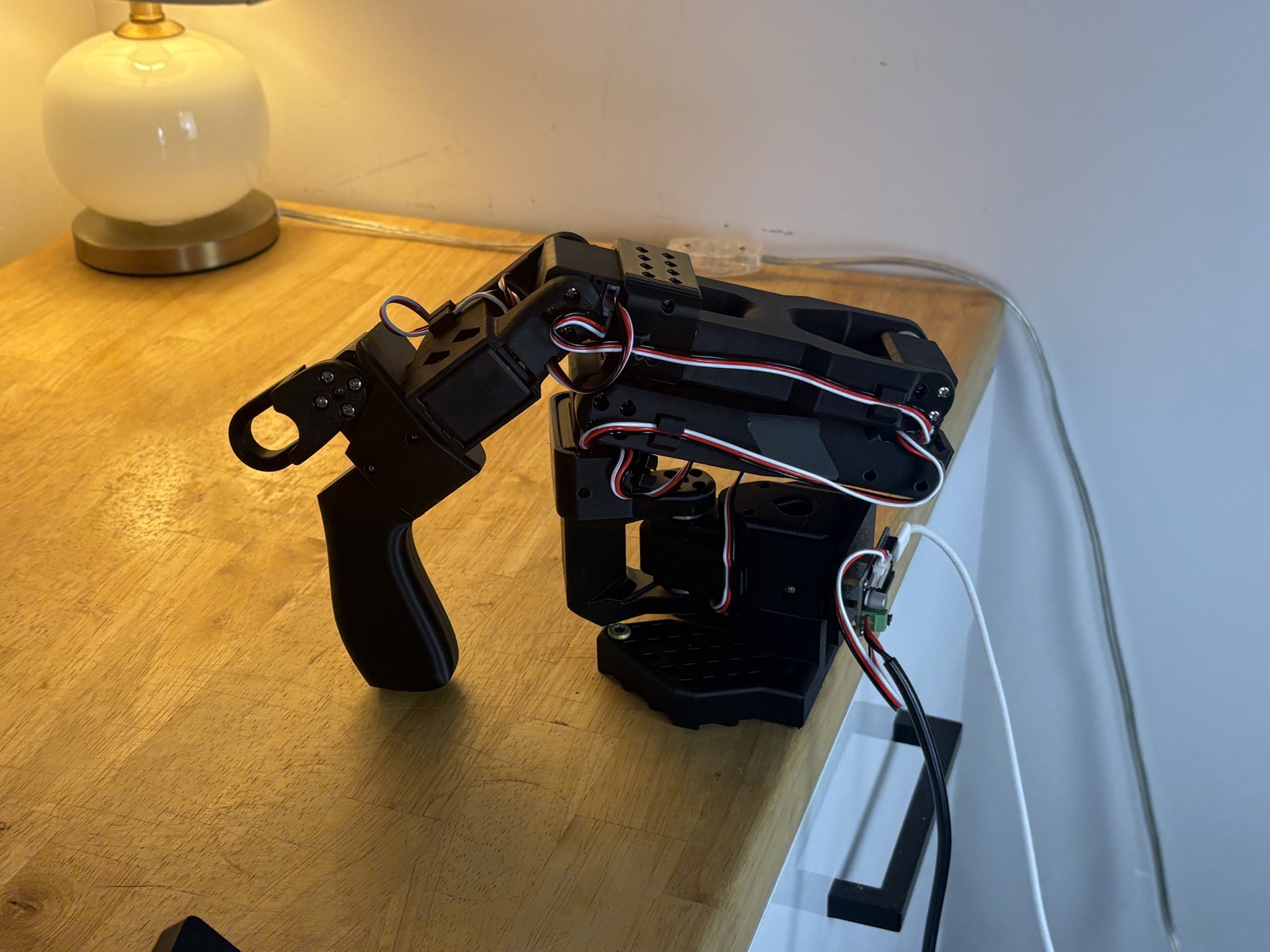 The SO-101 leader arm, with the handle and scissor grip for working the jaws.