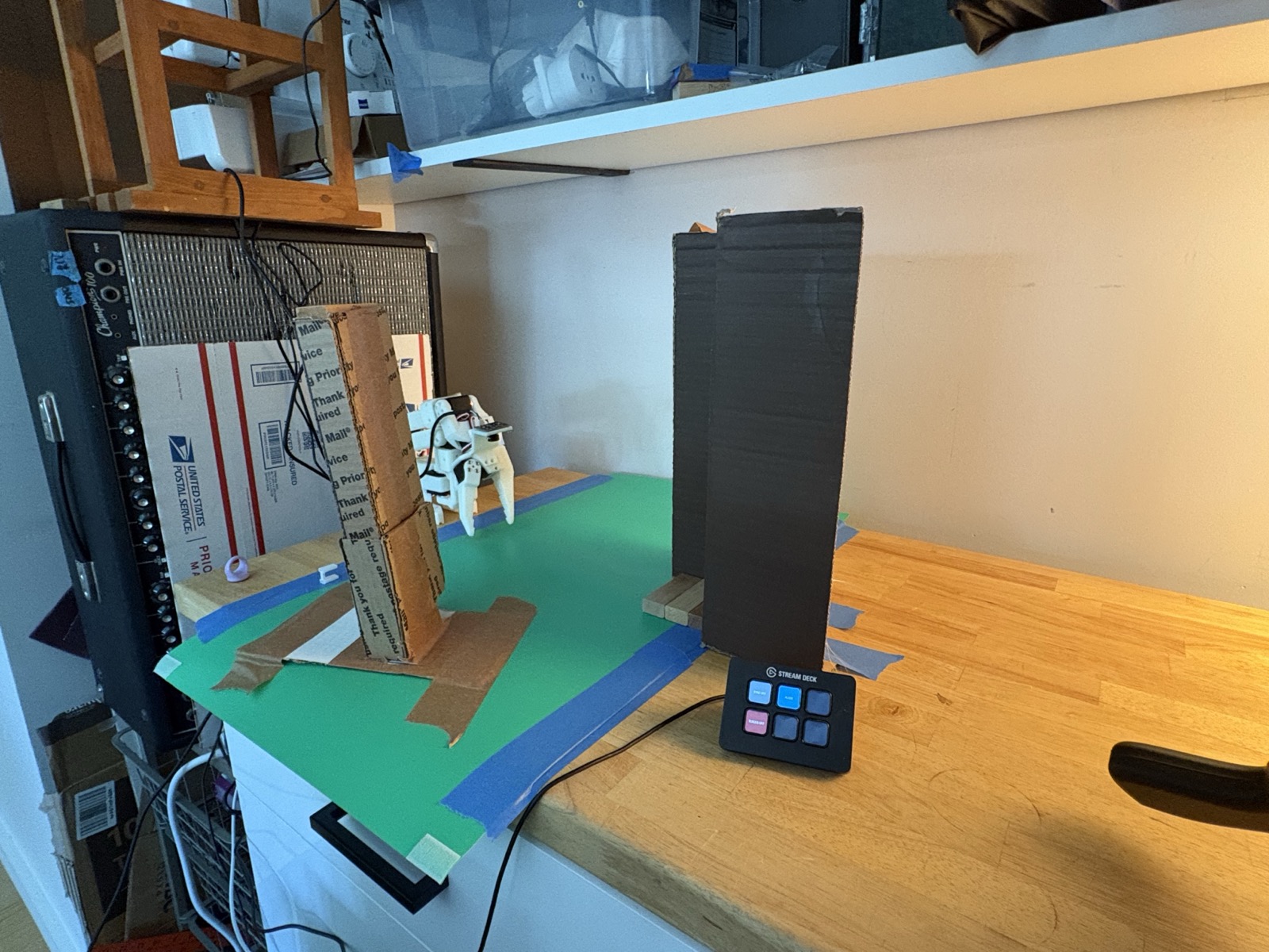 The reworked workspace: green backdrop, cardboard tower frame, and (later in the week) the dispenser and Stream Deck.